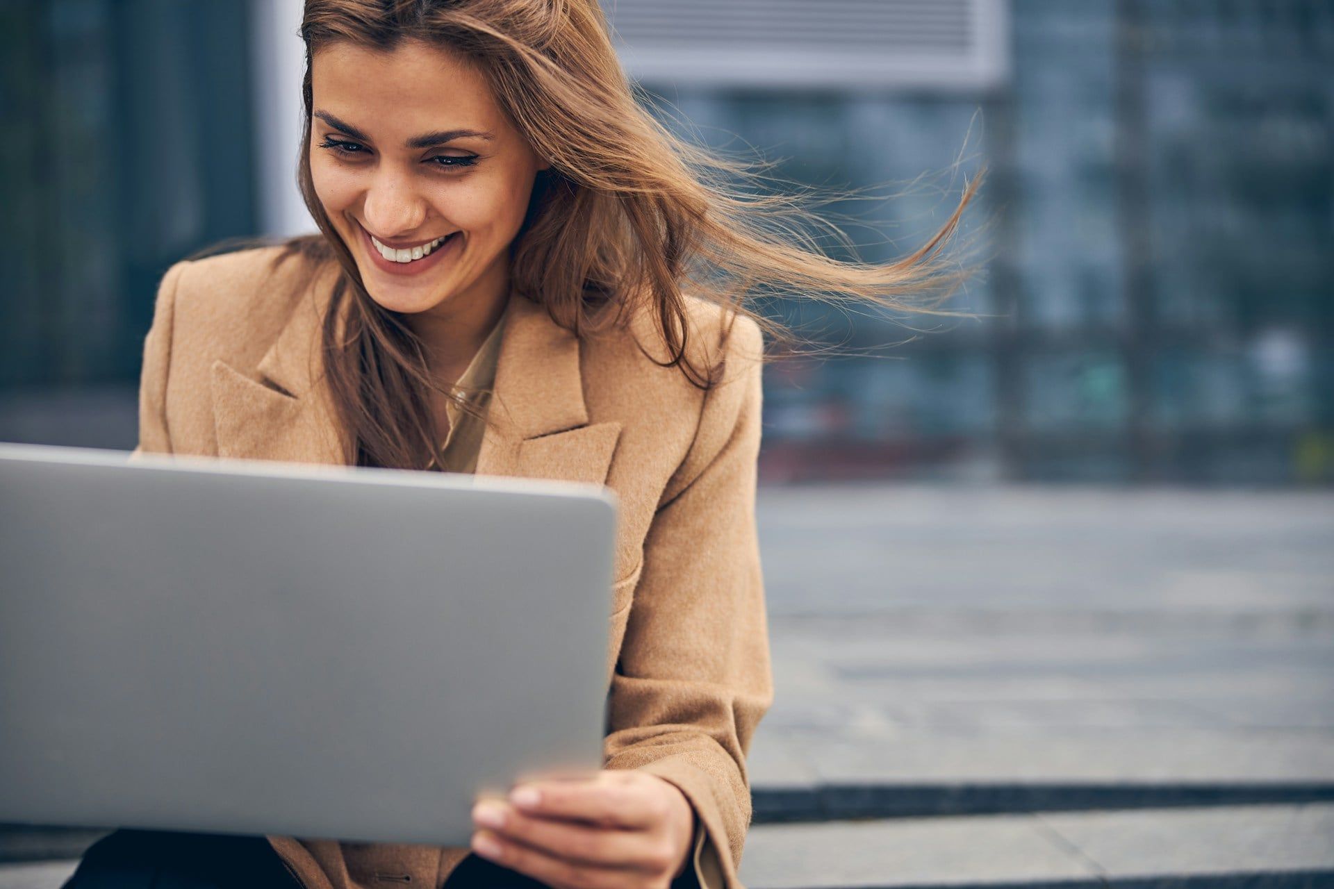  A female business owner sits outside with her laptop optimizing her Edmonton Google Business Profile