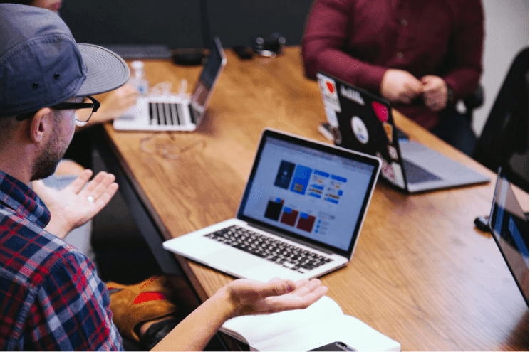 A business owner sits at a desk looking confused at their website on a laptop