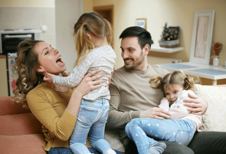 A family hanging out and playing on the couch at home