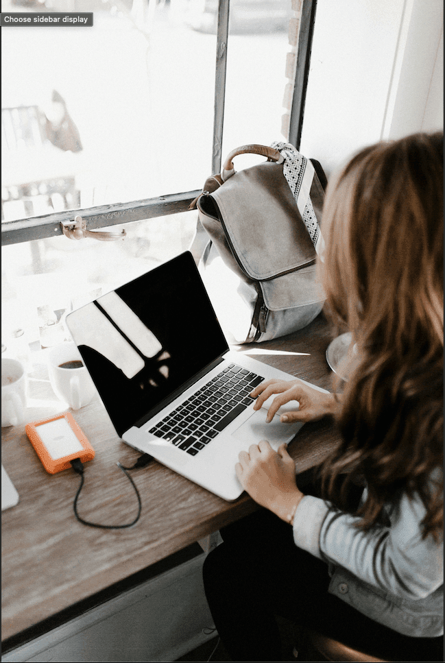 A girl sits at a desk, working intently on her computer, surrounded by a focused and productive atmosphere.