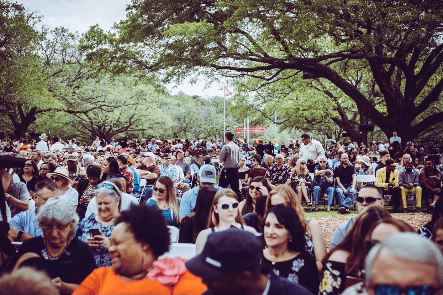 A large crowd of people gathered outdoors, creating a dynamic and lively atmosphere with diverse interactions and energy.