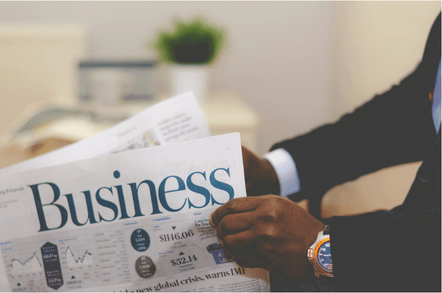 A man in a suit reading a newspaper.