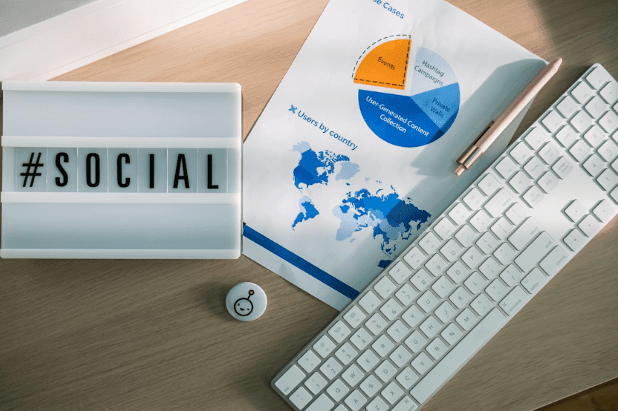 A social media sign, a report on paper, and a keyboard arranged together.