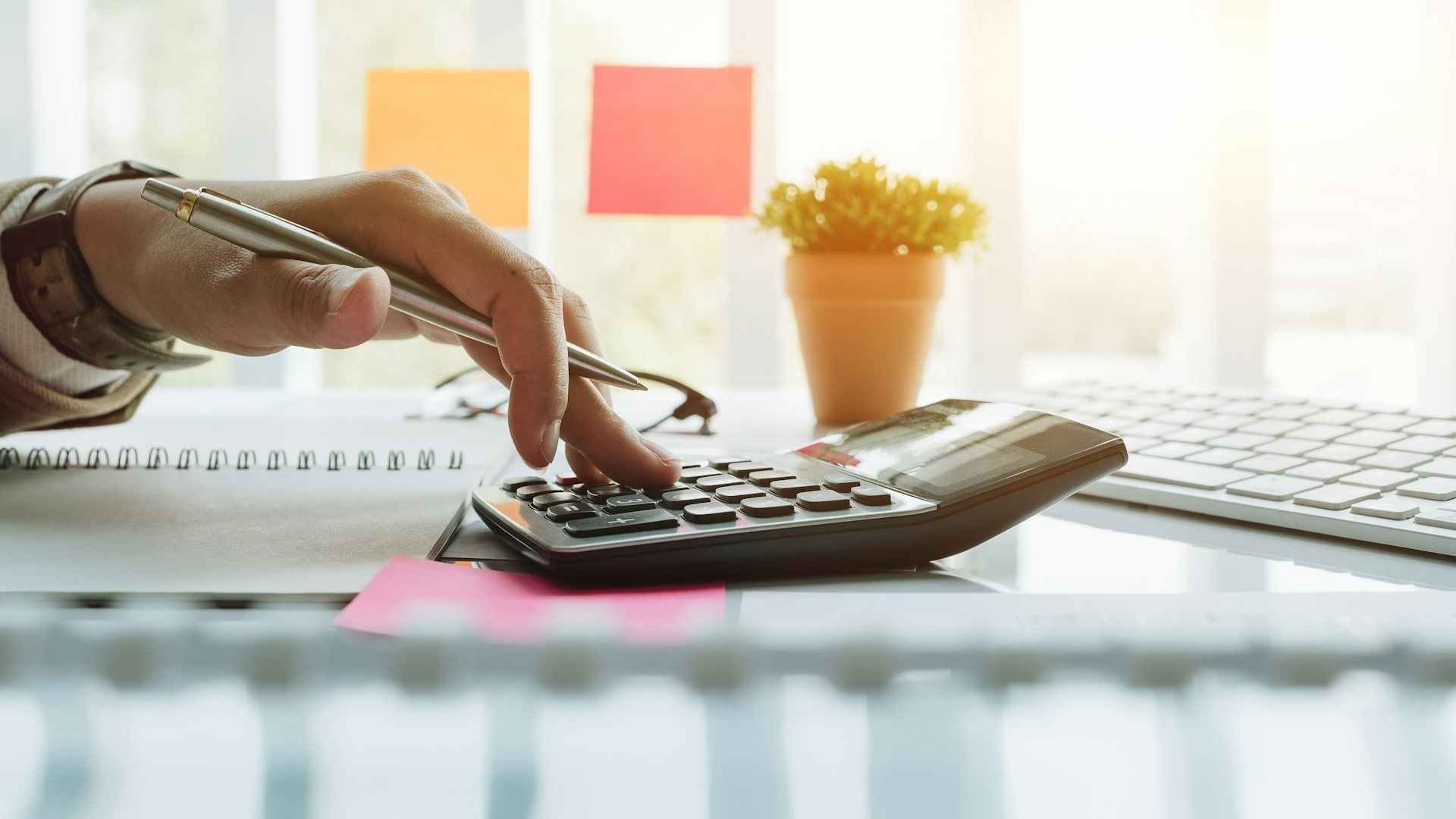 A shot of someone using a calculator at a glass desk to work out their SEO ROI