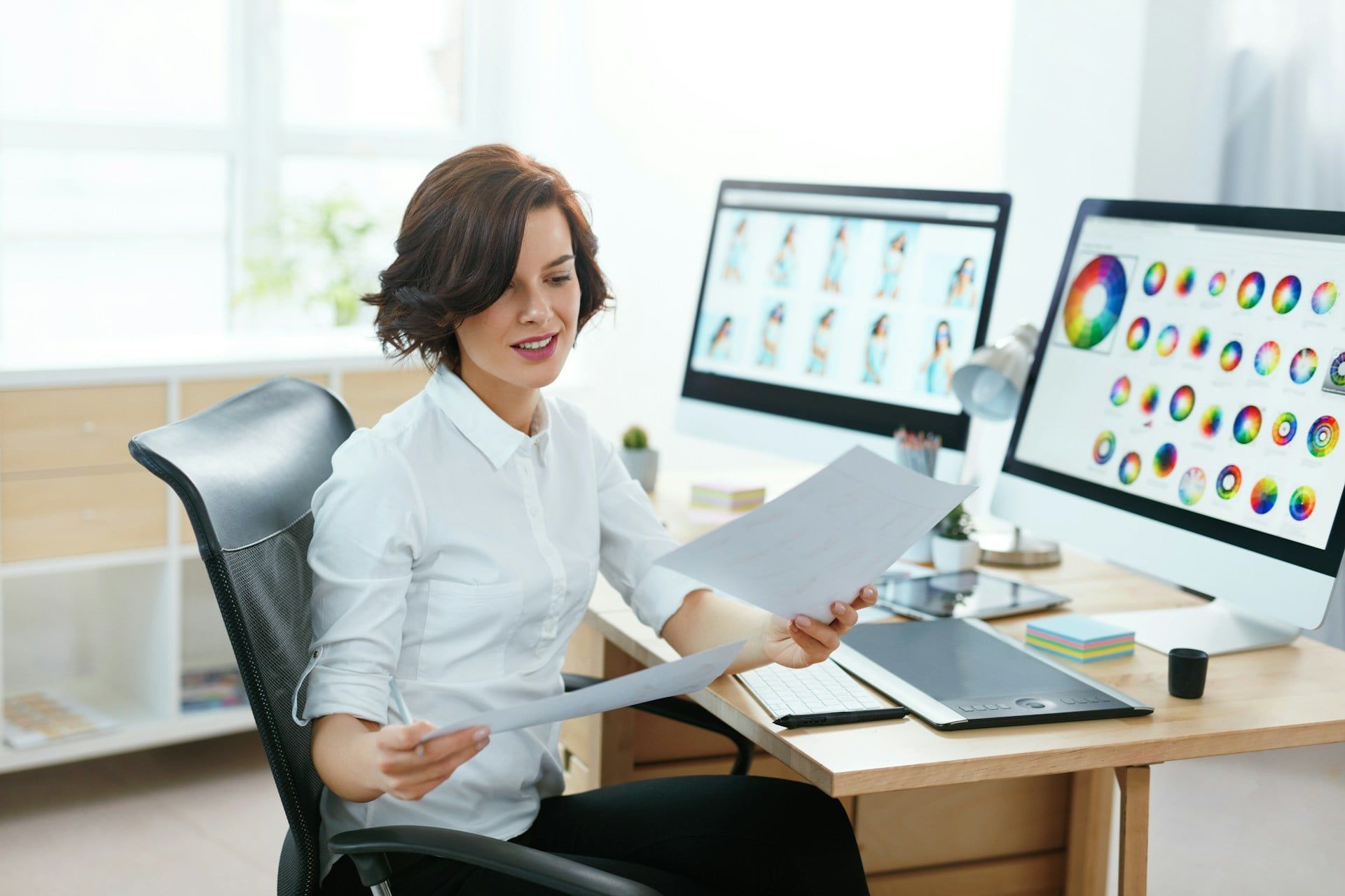 A web designer looking at different documents while choosing the palettes for her website