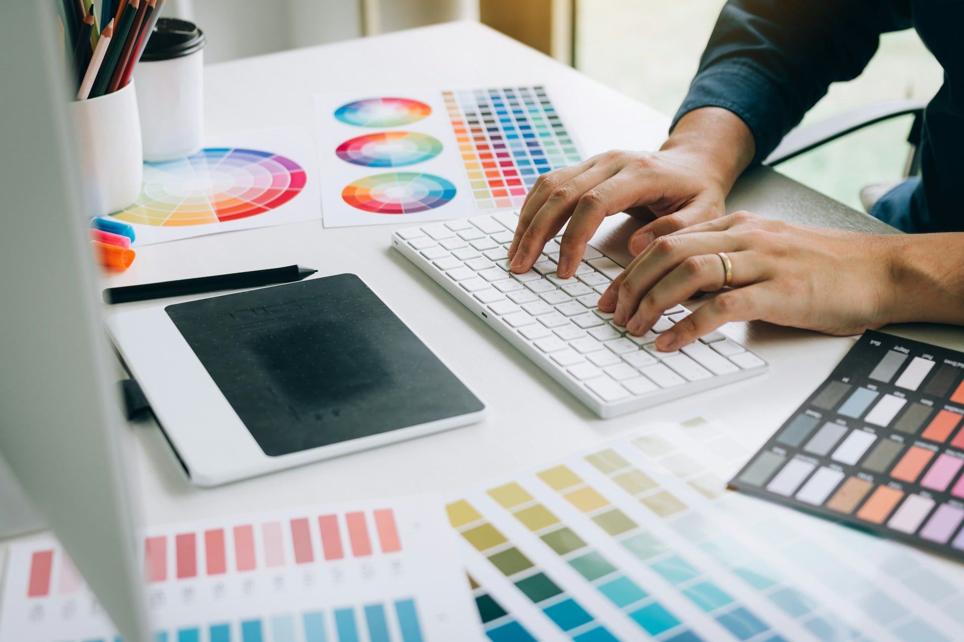 Someone working at a desk with colour sheets around them