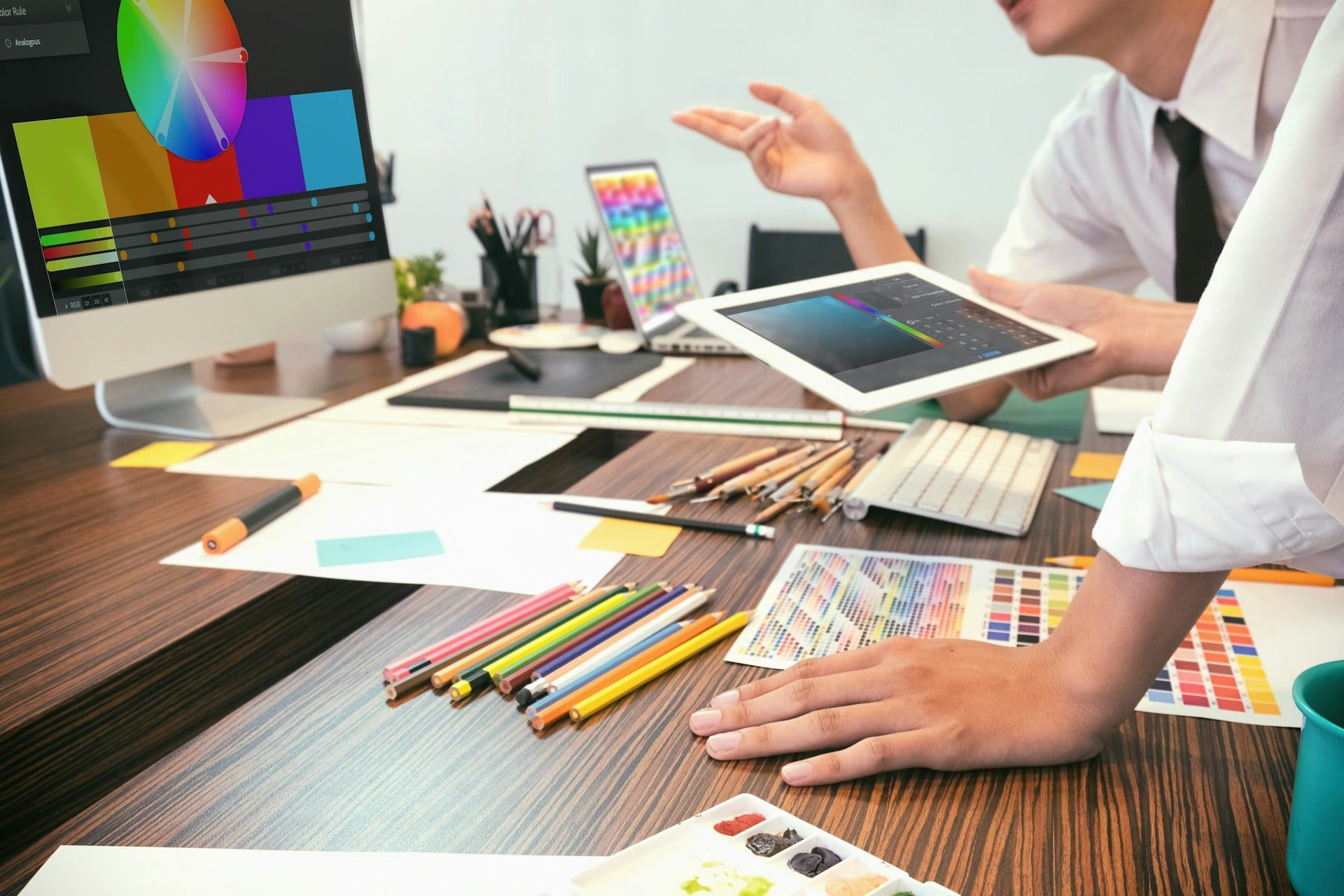  Designers working together with dozens of different coloured sheet and palettes around them
