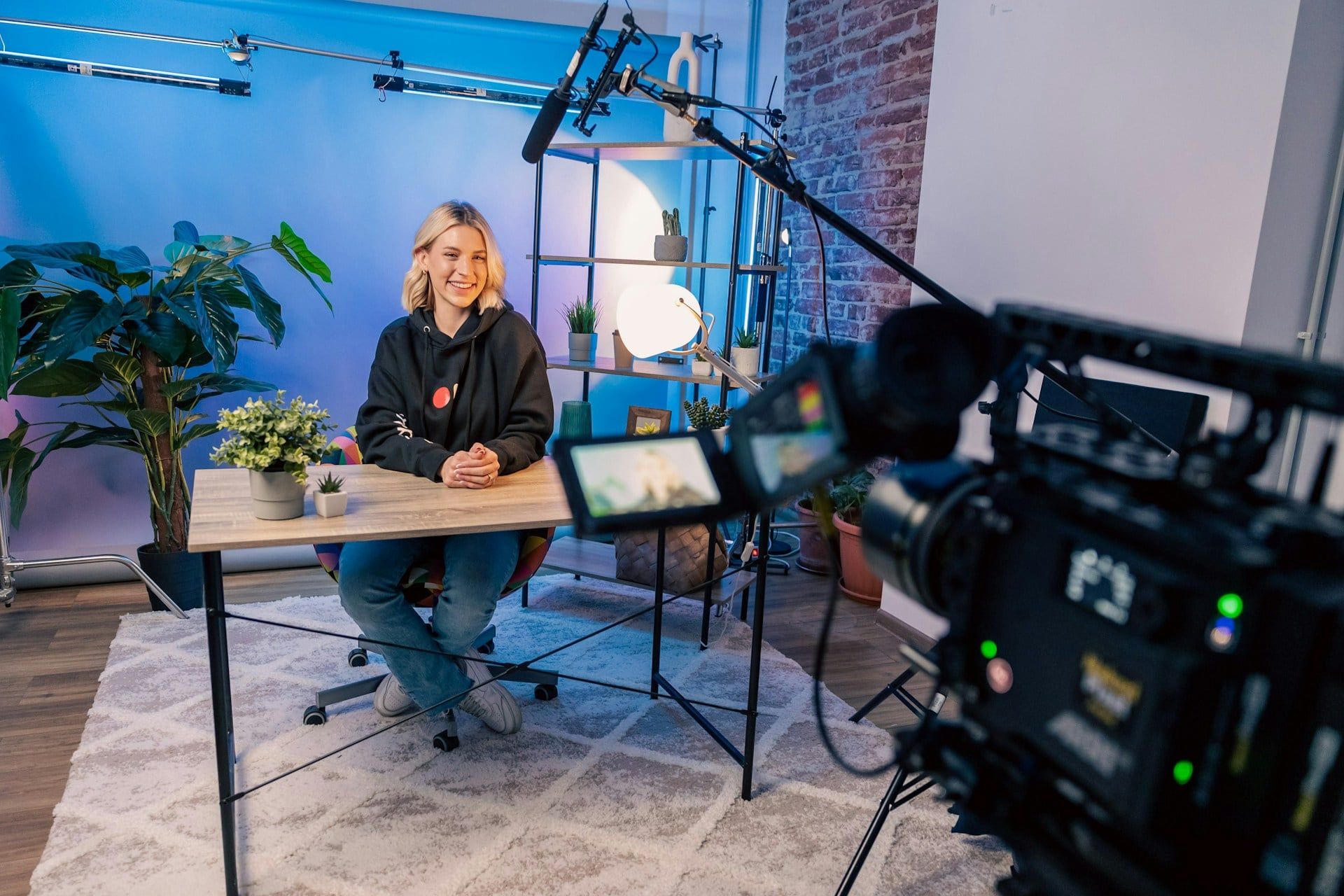 A female influencer sits down on set to record a video for her channel