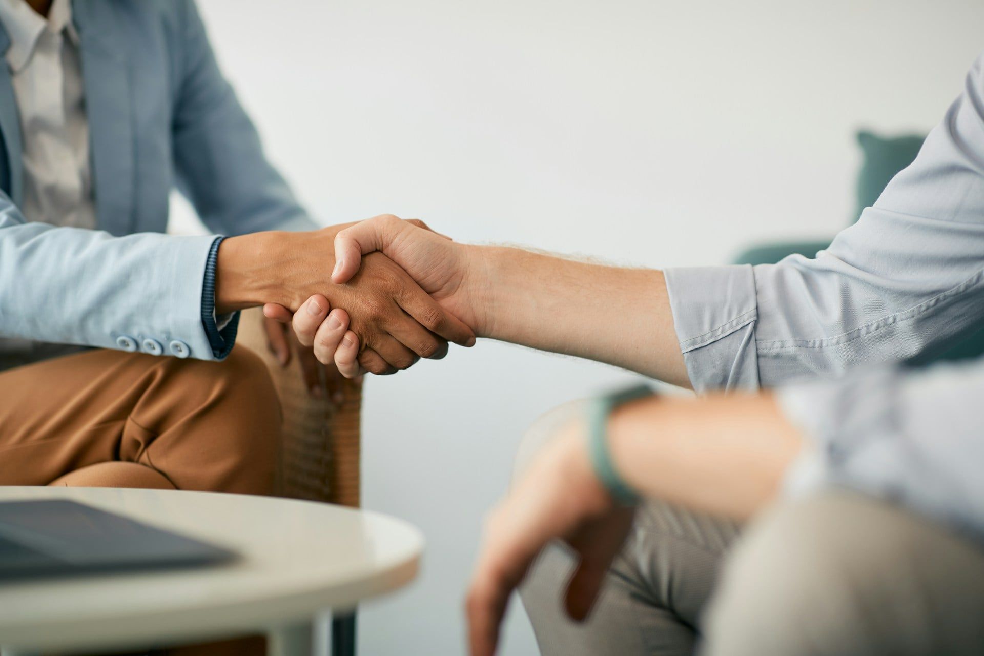 A close-up of two people shaking hands over a business deal