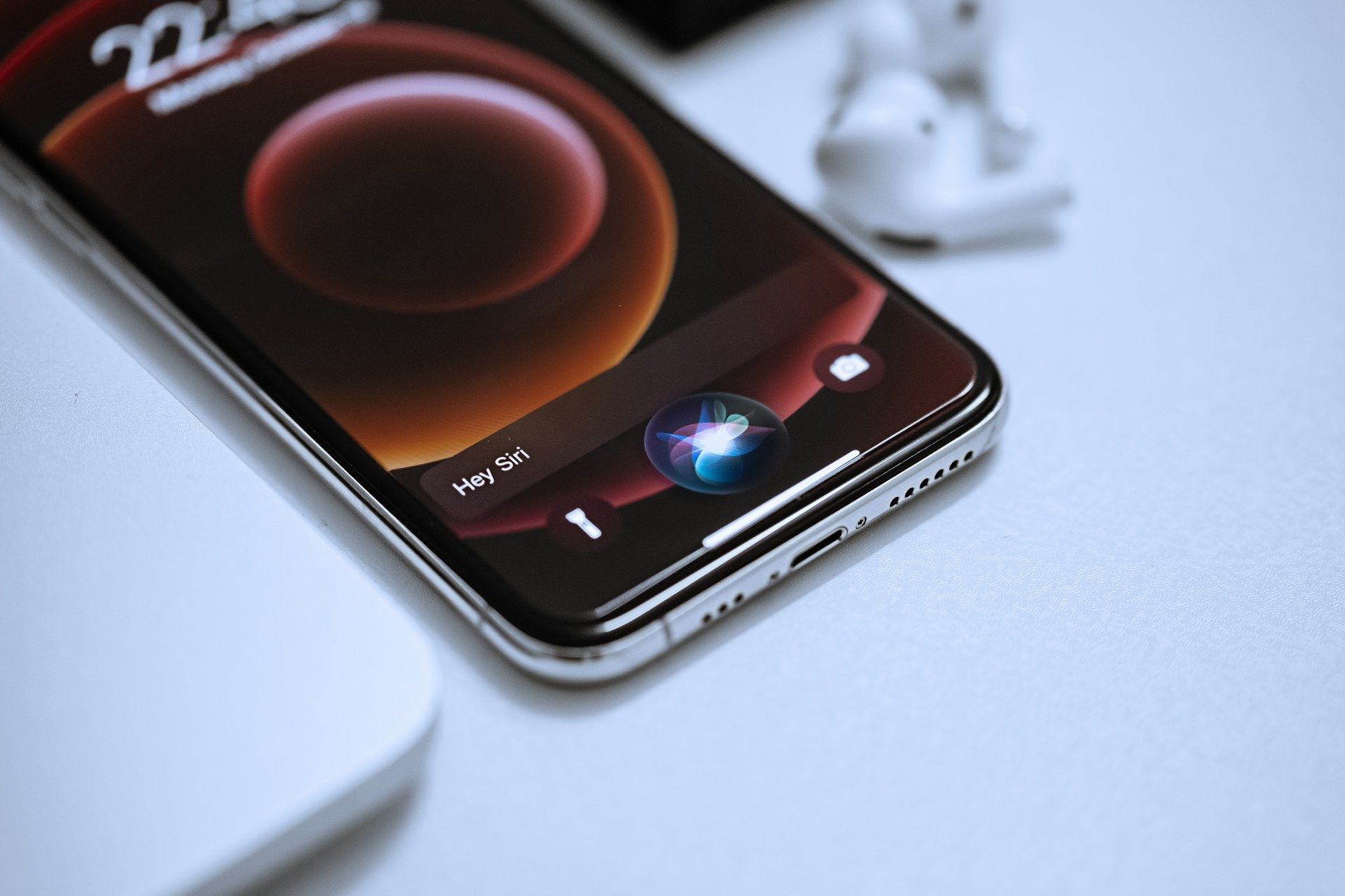 An iPhone with the Siri search bar open ready for a voice search