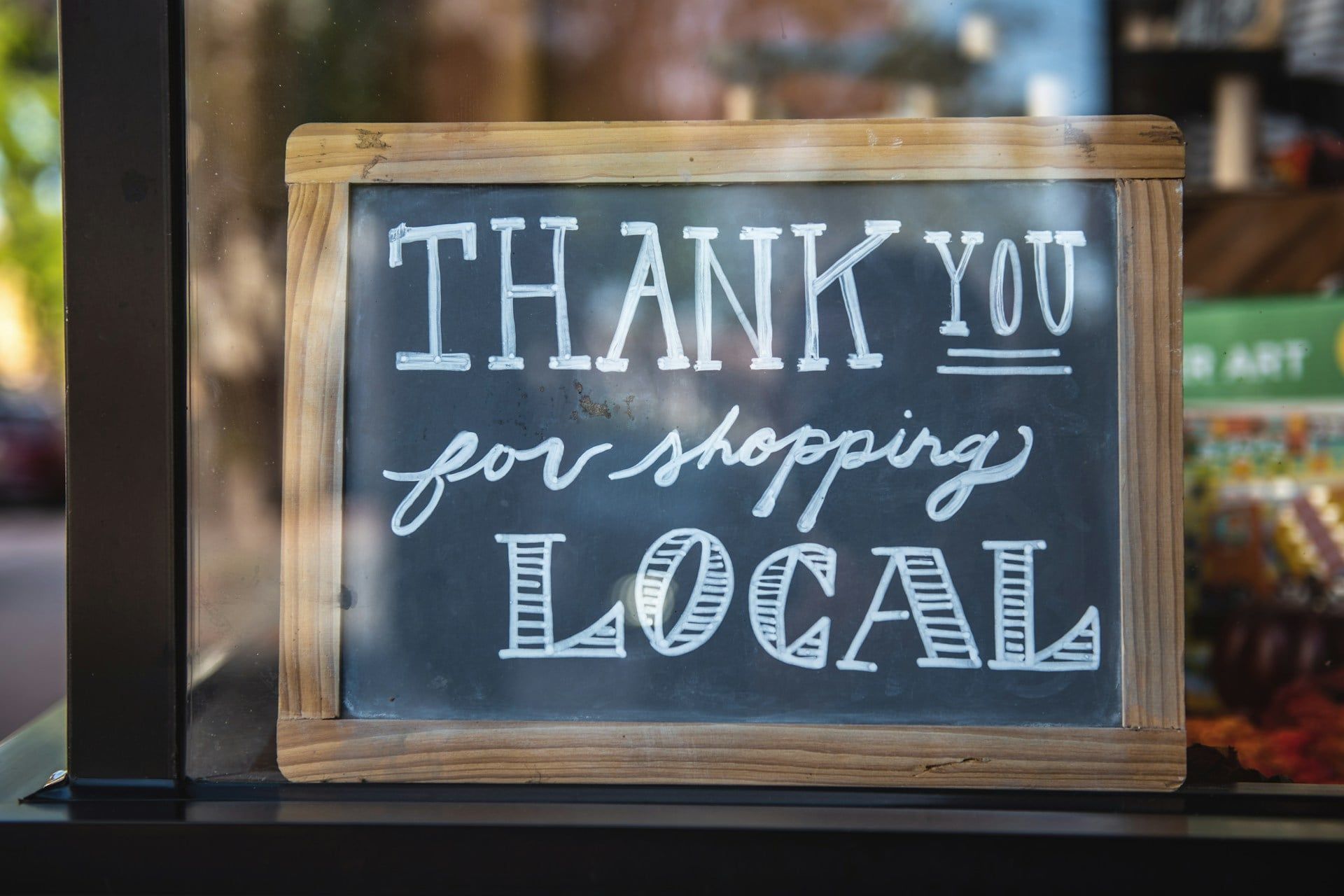 A chalkboard sign that reads “Thank you for shopping local”