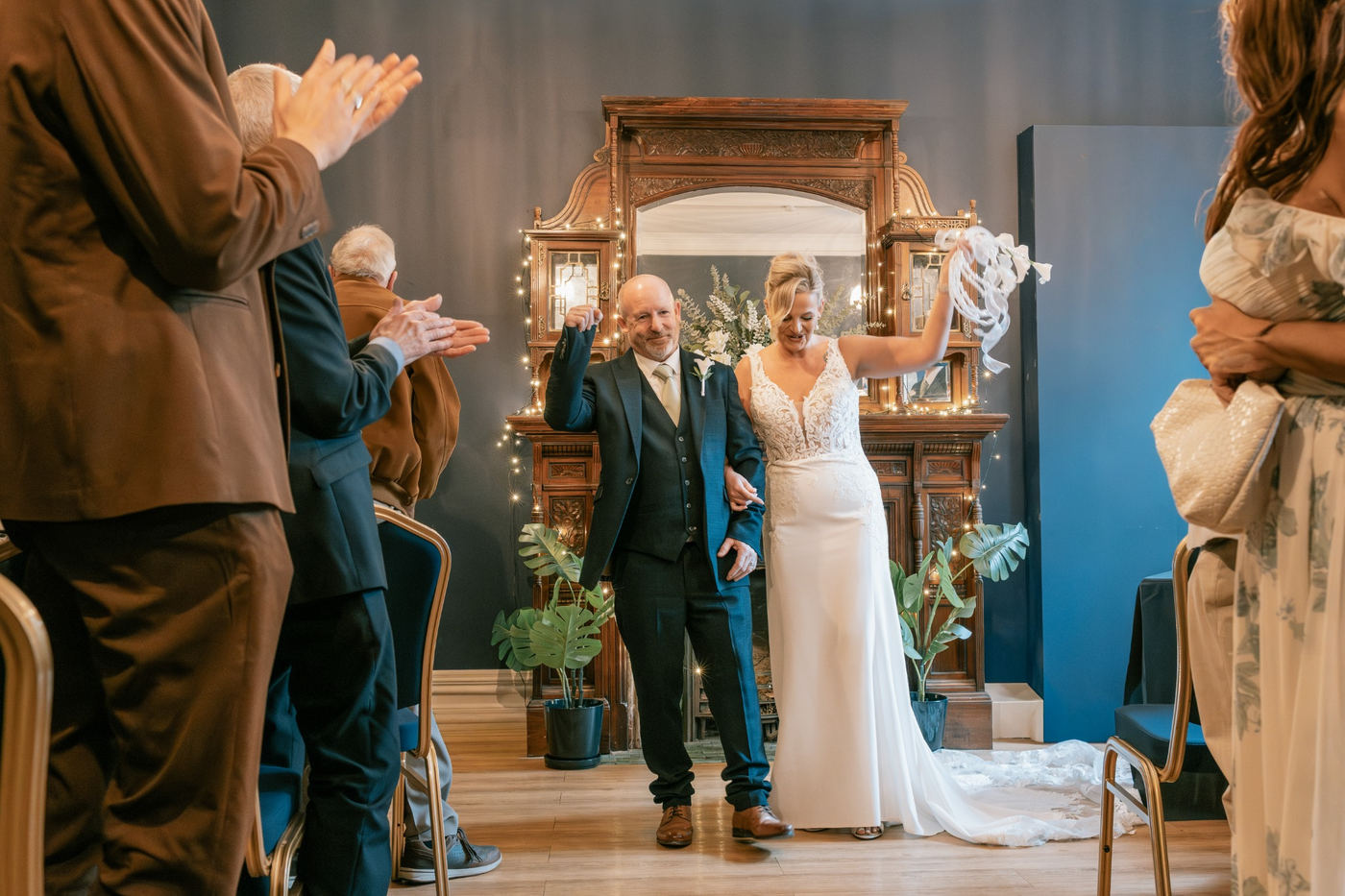 Newly married couple celebrating as guests applaud