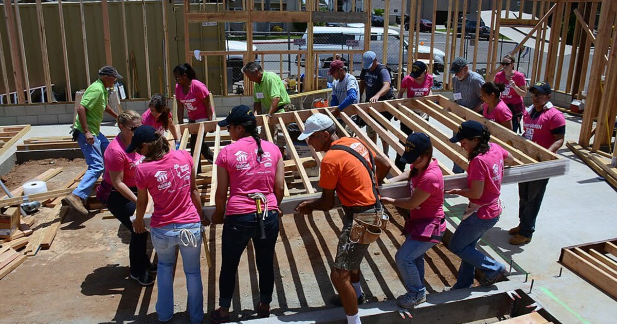 Volunteers work together to raise a timber wall during a 2014 Habitat for Humanity Women Build project.