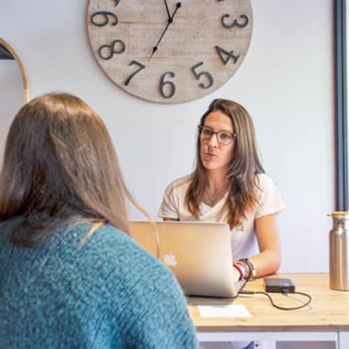 Lilou Leriche naturopathe assise derrière son bureau face a sa patiente en consultation