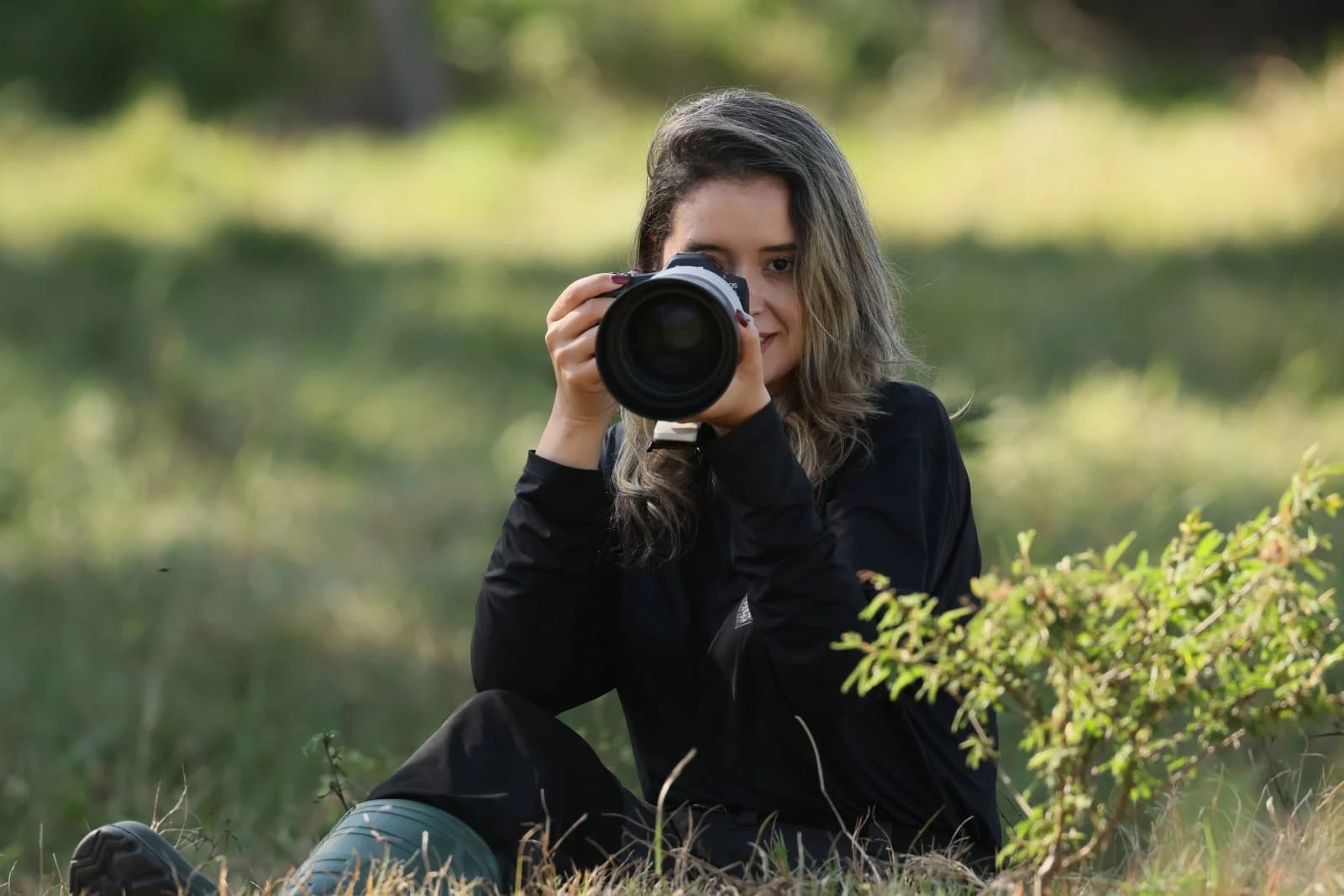 Jéssica Menq com câmera em campo — bióloga do Planeta Aves