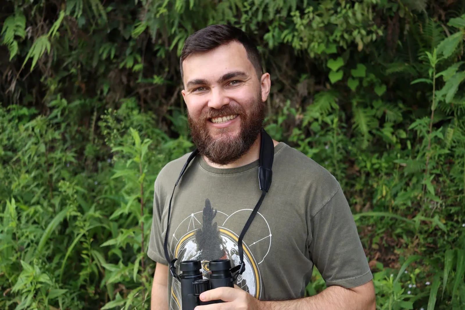 Willian Menq com binóculos — biólogo e ornitólogo do Planeta Aves