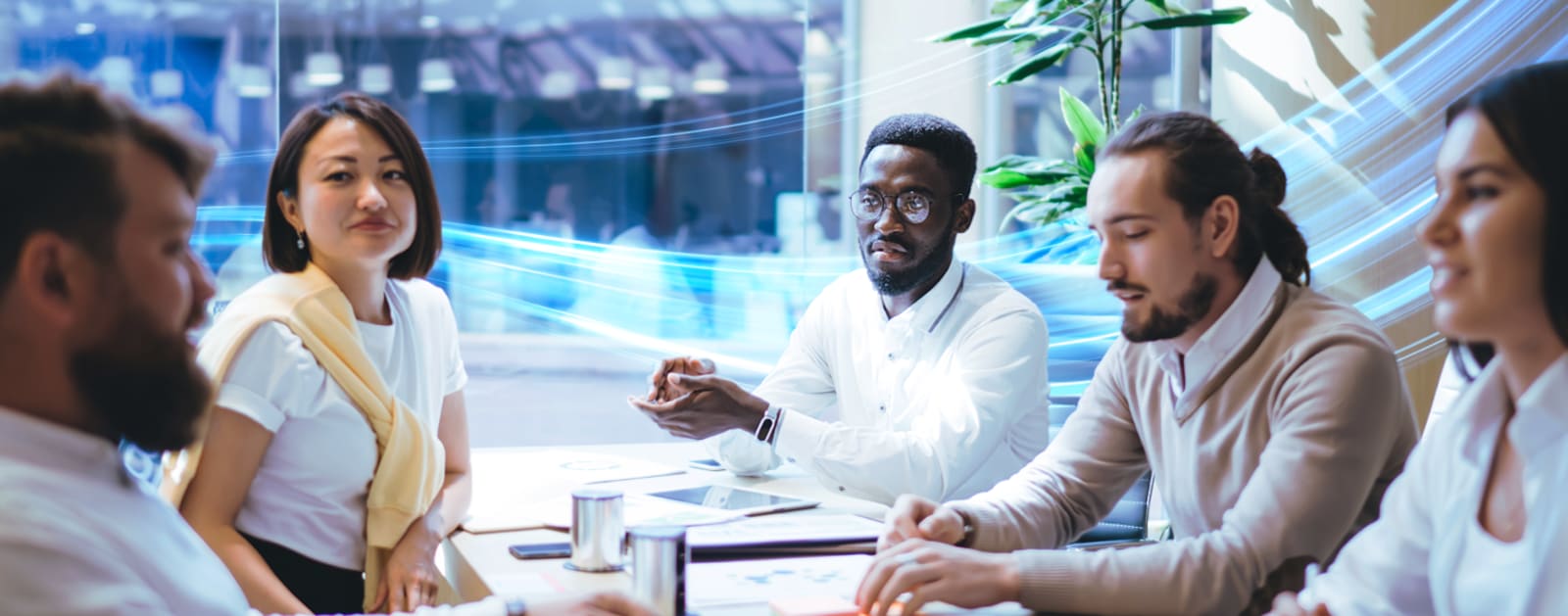 A workplace team discussing topics while sitting at a desk