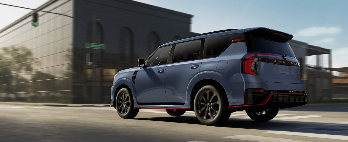 2027 Nissan Armada NISMO driving through the city, rear three-quarter view