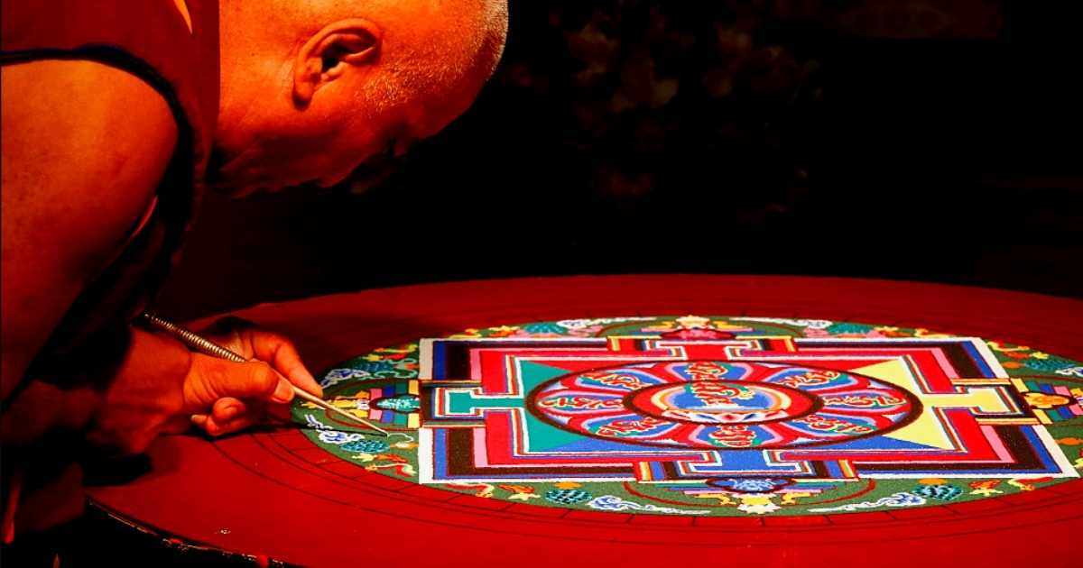 old monk drawing traditional thanks during mani rimdu