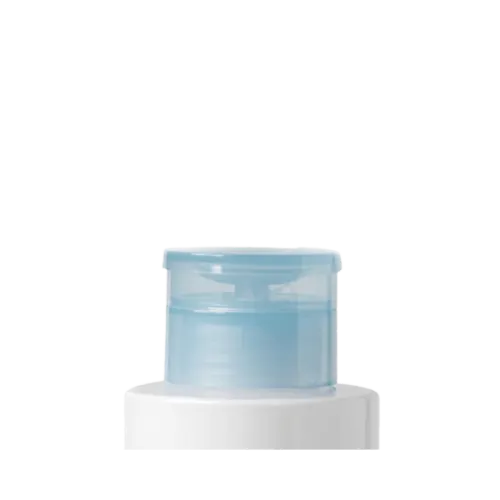 The image shows the Quadpack PP Pump, a sleek and modern dispensing pump designed for liquid products. The pump is primarily white with a cylindrical shape and a nozzle for dispensing. The design appears ergonomic, making it easy to use and suitable for various liquid containers.