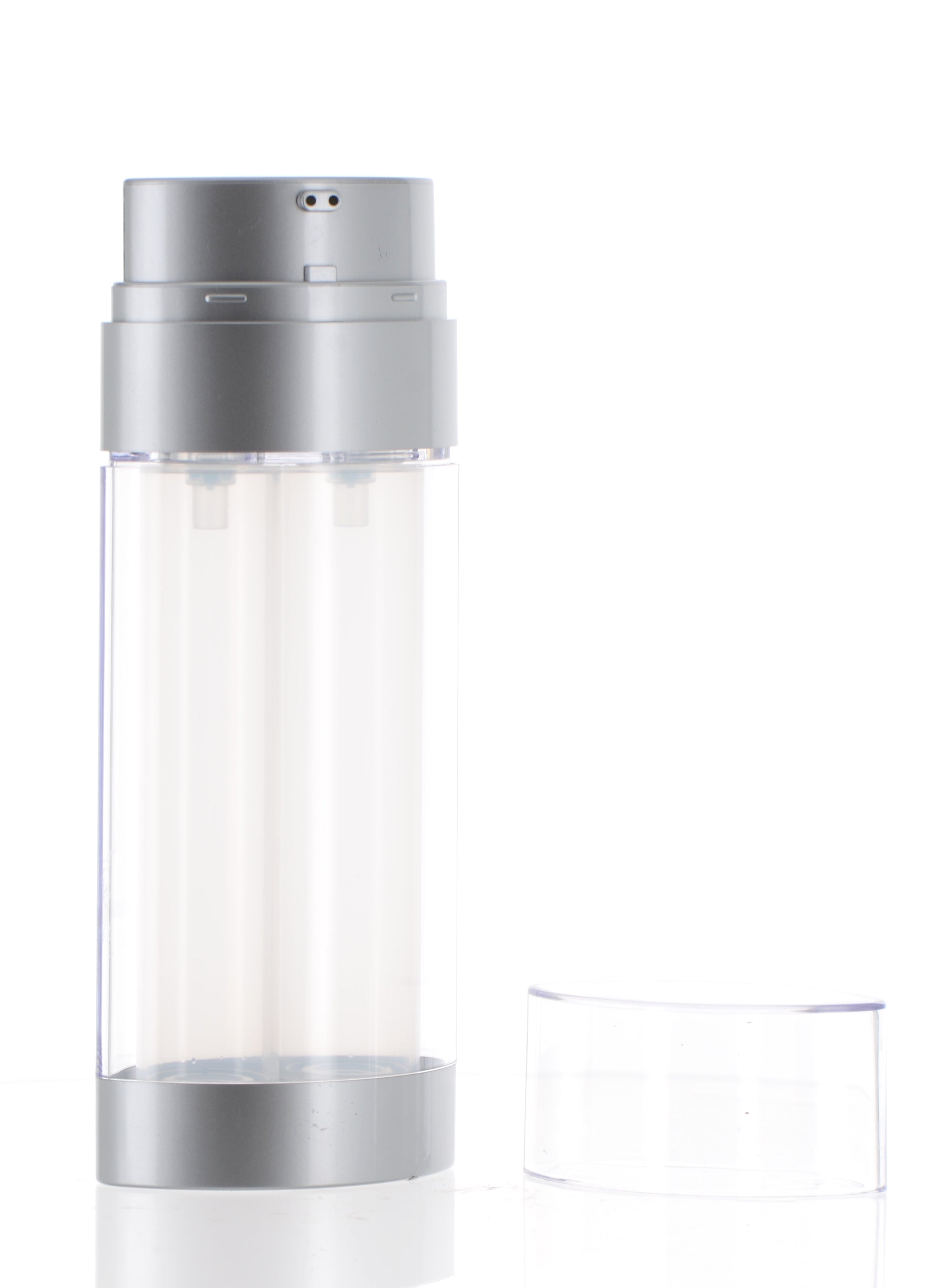 The image shows the APG Packaging 2.0oz PP Airless Bottle. The bottle is sleek and cylindrical with a metallic silver finish. It features a clear cap that reveals a pump dispenser underneath. The overall design is modern and elegant, suitable for high-end cosmetic products. The bottle is standing upright, showcasing its smooth, reflective surface and minimalist aesthetic.