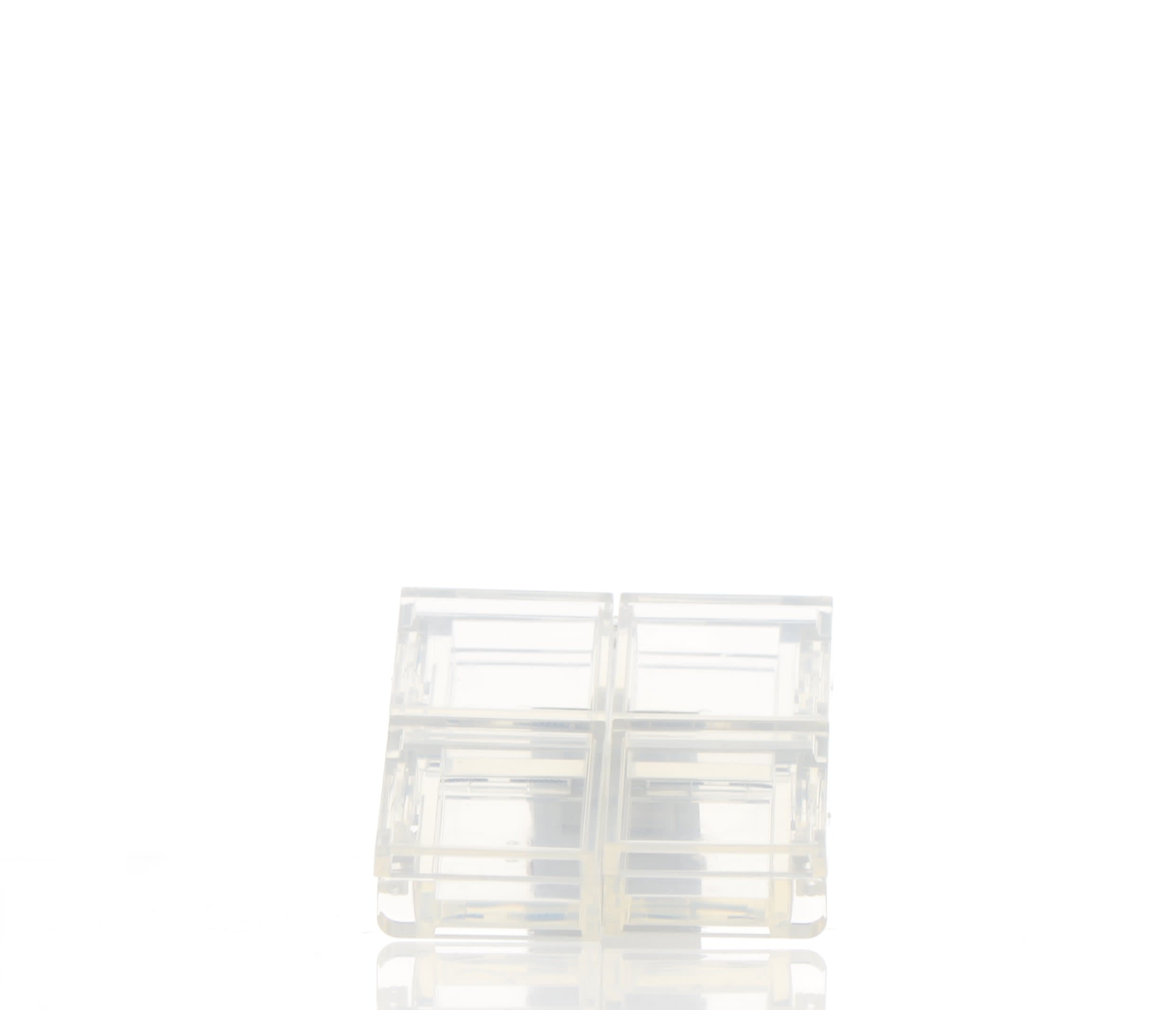 The image features the APG Packaging 0.0oz PETG Compact (APG-400015). The compact is a small, rounded, and translucent container with a clear lid. The lid is hinged and allows visibility of the contents inside. The compact's base is also translucent, matching the lid, and provides a sleek and modern appearance. The overall design is minimalist and functional, suitable for holding small amounts of cosmetic products.