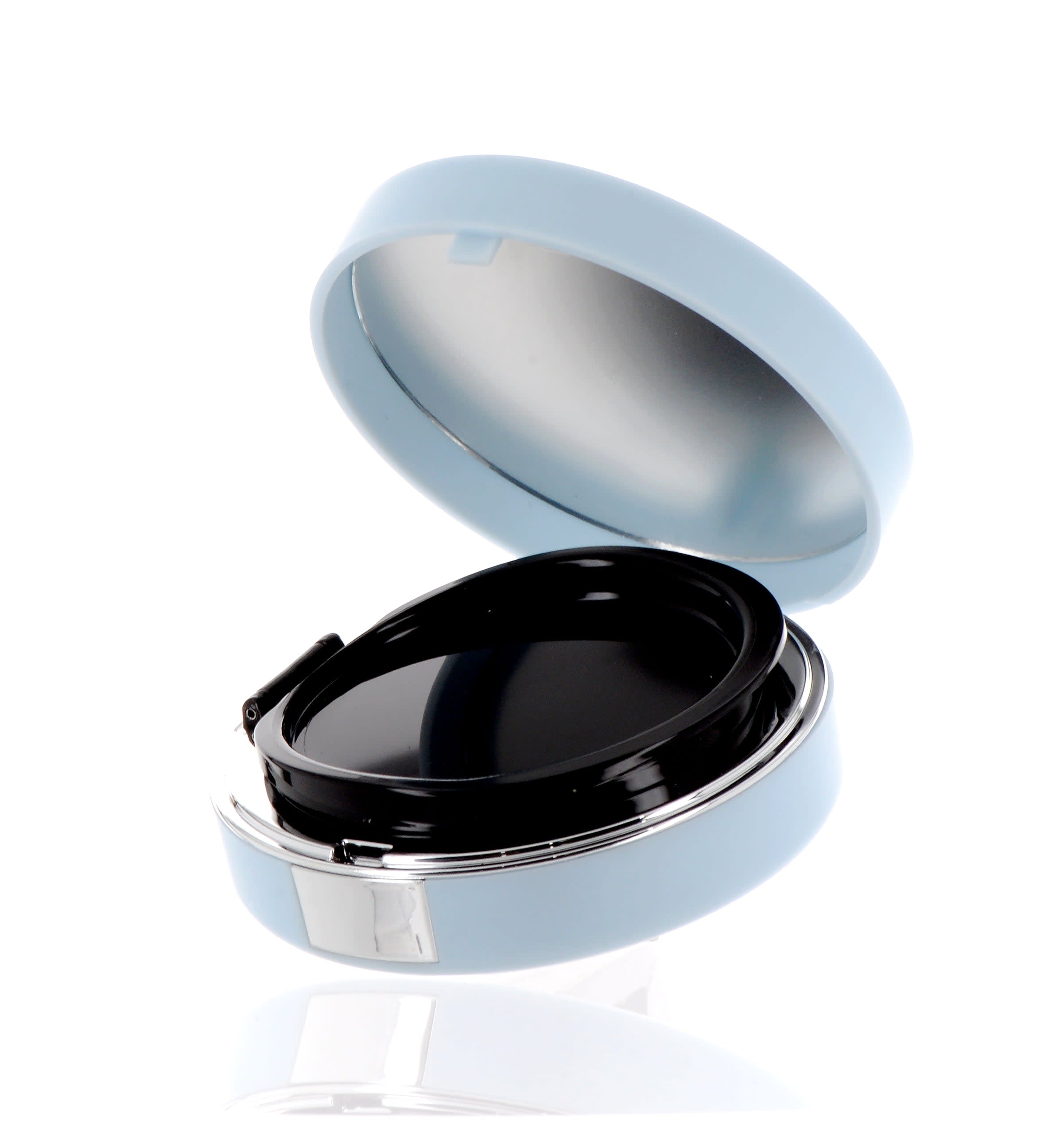 The image shows the APG Packaging 0.0oz Mixed Material Compact (APG-C503-BBS). It is a small, round compact case with a sleek, black exterior. The compact features a glossy finish and appears to have a secure closure mechanism. The lid of the compact is slightly domed and smooth, giving it a modern and elegant appearance. The overall design is minimalistic and stylish, suitable for holding small quantities of cosmetic products.