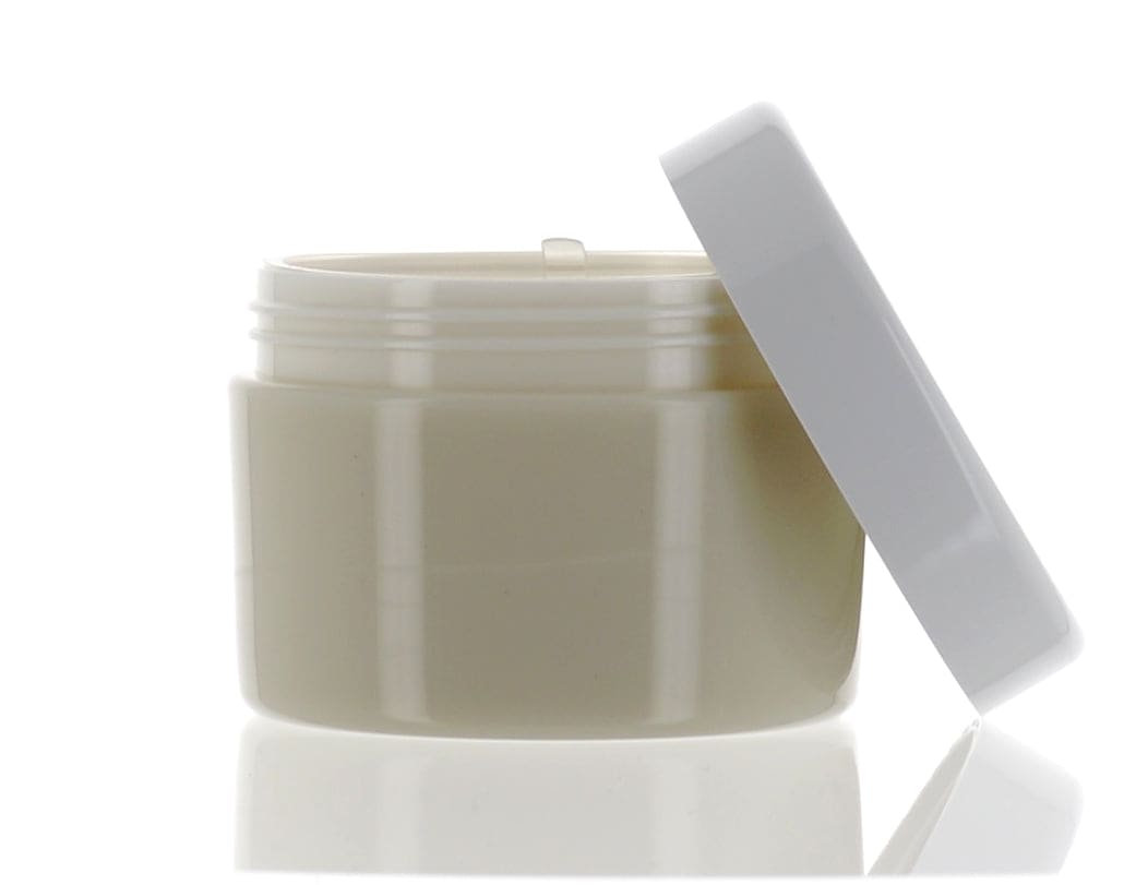 The image features the APG Packaging 3.4oz Mixed Material Jar with the APG-U-100FR cap. The jar is clear and cylindrical, showcasing its contents, while the cap is white and fits snugly on top. The design is simple and functional, highlighting the product's capacity and material.