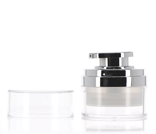 The image shows the APG Packaging 2.4oz Acrylic Airless Jar (APG-A10-30). The jar has a sleek, cylindrical shape with a clear acrylic body and a silver-toned lid. The transparent body allows visibility of the contents inside, and the overall design is modern and elegant. This airless jar is designed for storing cosmetic products, ensuring an air-tight seal to preserve the contents. The lid appears to have a smooth, reflective surface, adding a touch of sophistication to the packaging. 