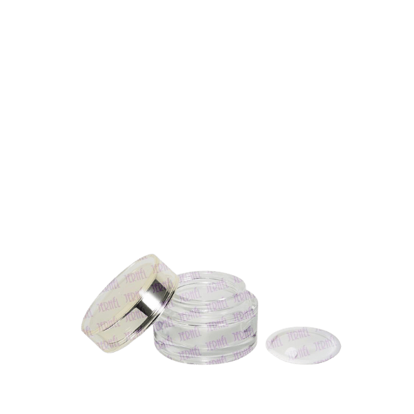 The image displays the "Jerhel Plastics Inc. 1.7oz Glass Jar (JI-2189)." The jar is made of clear glass and has a cylindrical shape with smooth, straight sides. The jar is topped with a silver, metallic screw-on lid that fits snugly. The overall design is minimalist and sleek, suitable for various cosmetic or skincare products.
