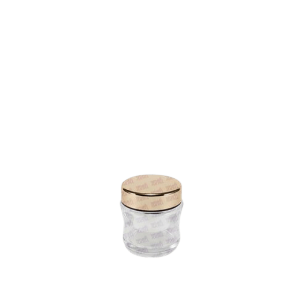 The image features the Jerhel Plastics Inc. 1.7oz Glass Jar. The jar is transparent, showcasing its smooth, clear glass material. It has a cylindrical shape with a wide opening at the top, designed to be sealed with a lid (not shown in the image). The jar's compact size and minimalist design make it suitable for holding small quantities of products such as cosmetics or food items. The clean and simple aesthetic highlights the jar's functionality and versatility.