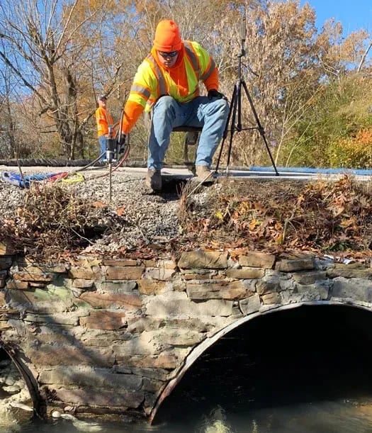 URETEK technician scaling rounded culvert