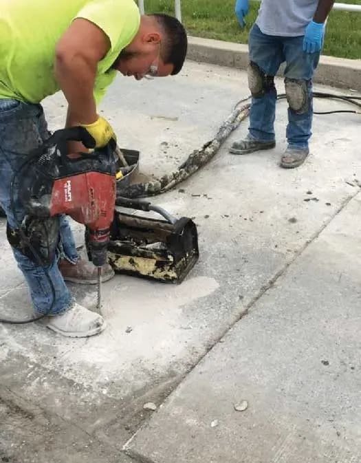 URETEK technician drills hole as another observes