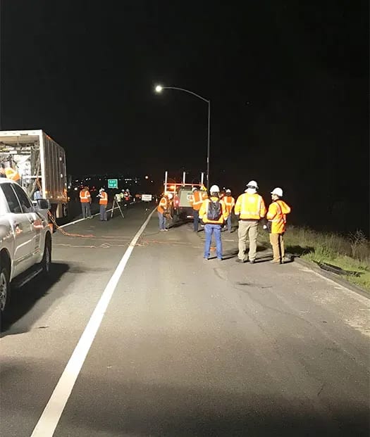 Large URETEK team in conversation at night on roadway