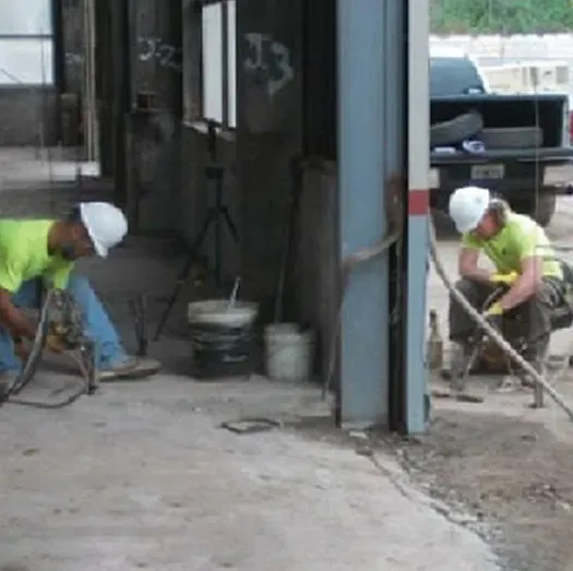 Two URETEK technicians kneeling at work