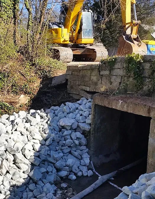 Culvert with crane on bridge above