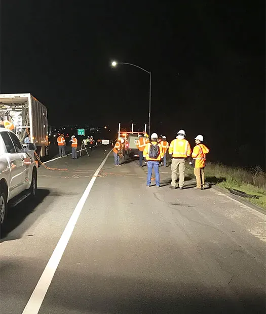 Large URETEK team in conversation at night on roadway