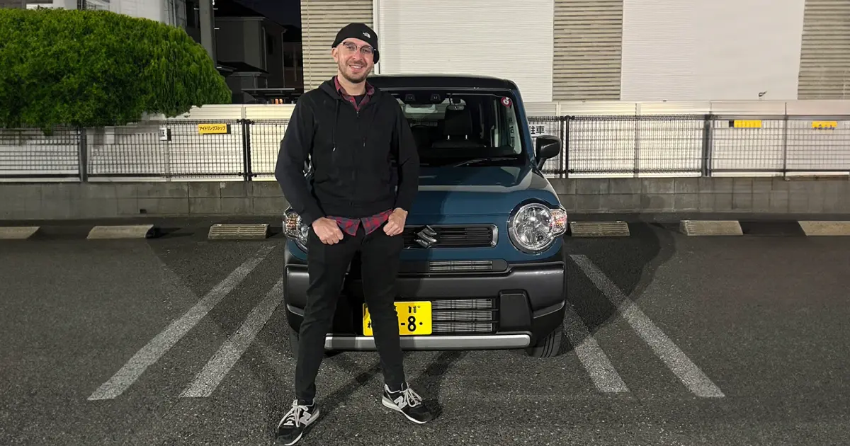 man standing next to Suzuki Hustler