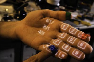 Finger dialing number on a palm with projected numbers