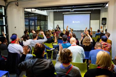 People watching a talk and raising their hands