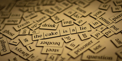 A picture of many pieces of a puzzle of words showing the composition of the sentence the cake is a lie.