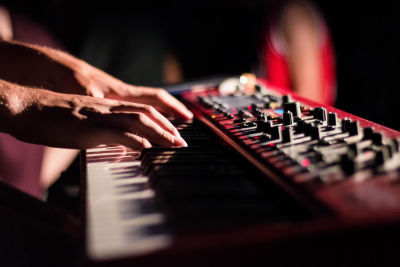 A performer plays a digital piano onstage