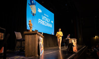 Vitaly on stage in front of a slide saying Welcome