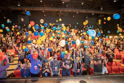 Conference attendees standing up throwing balloons