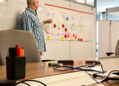 Prospective designer discussing their process through a whiteboard exercise during an interview.