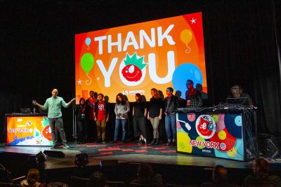 A large group of people on stage under a slide that says Thank You.