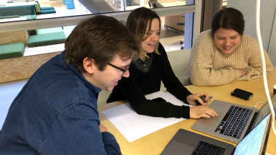 Three people are smiling and sitting next to each other around a computer. From left to right, they are Dag-Inge (CTO), Ida (CPO) and Ingvild (Sr. Engineer).