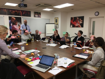 People holding up a red or a green card to tell the facilitator how they got on with the task