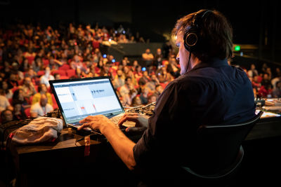 Photo of DJ Tobi Lessnow on stage with the crowd watching