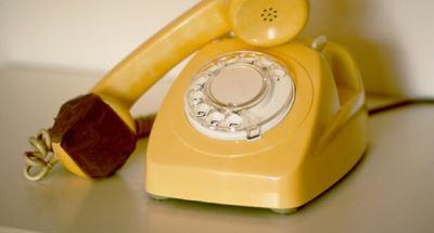 An image of a landline phone with the microphone blocked.